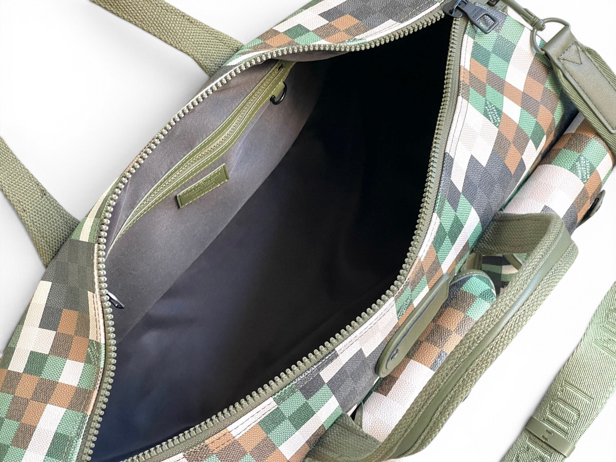 SWORD LUXURY Louis Vuitton Keepall 50 seyahat çantasının içi, yeşil, kahverengi ve bej tonlarında piksel kamuflaj desenli.