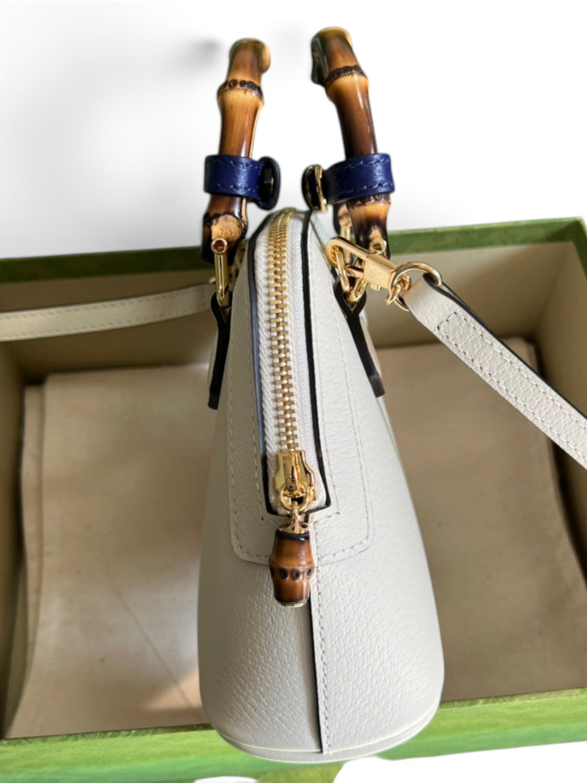 SWORD LUXURY Diana deri çanta, bambu saplı, mor detaylı ve altın tonlu fermuarlı, kutusu içinde yan görünüm.