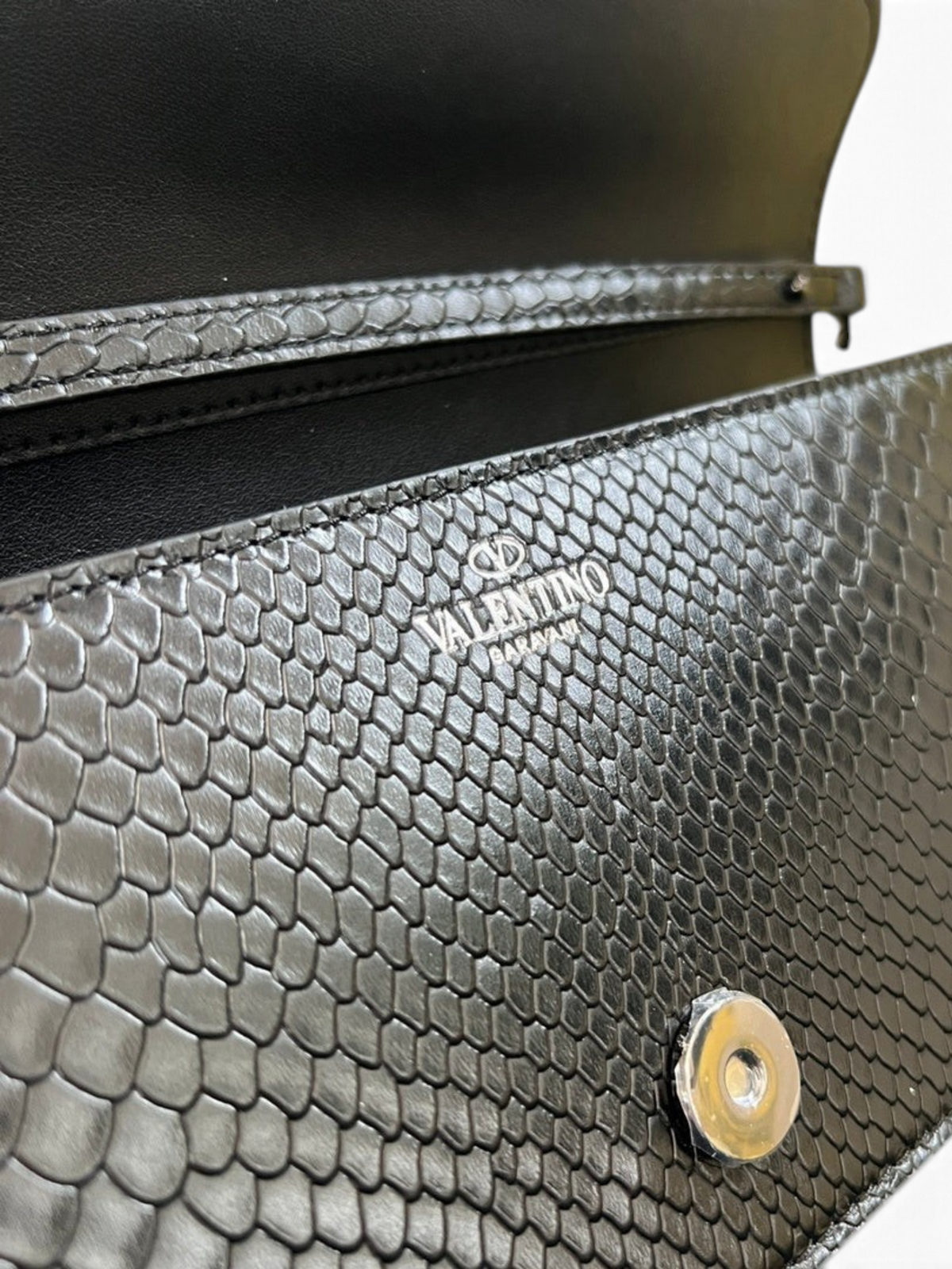 SWORD LUXURY Valentino Garavani VLogo siyah Ayers deri çanta, dokulu yüzeyi ve metalik detaylı kapak tasarımı ile.