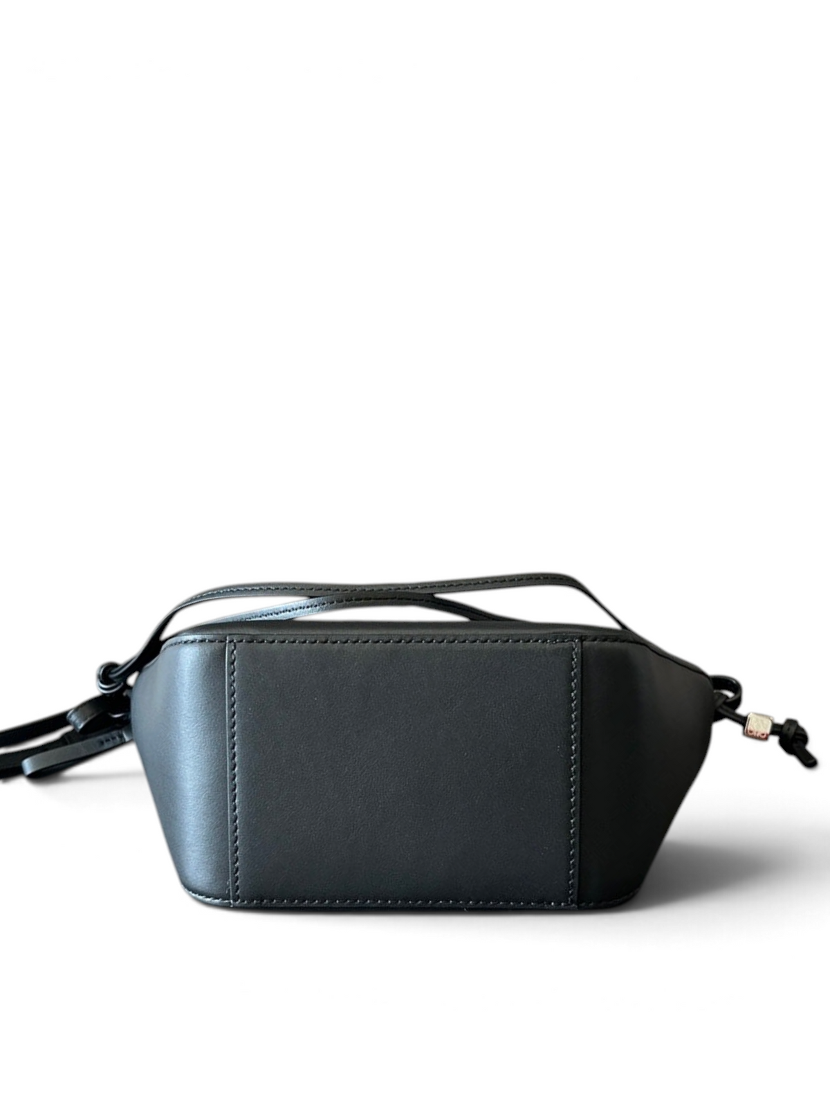 SWORD LUXURY imzalı, siyah deri Loewe Mini Hammock çanta, düz bir yüzey üzerinde yan profilden görünüm.