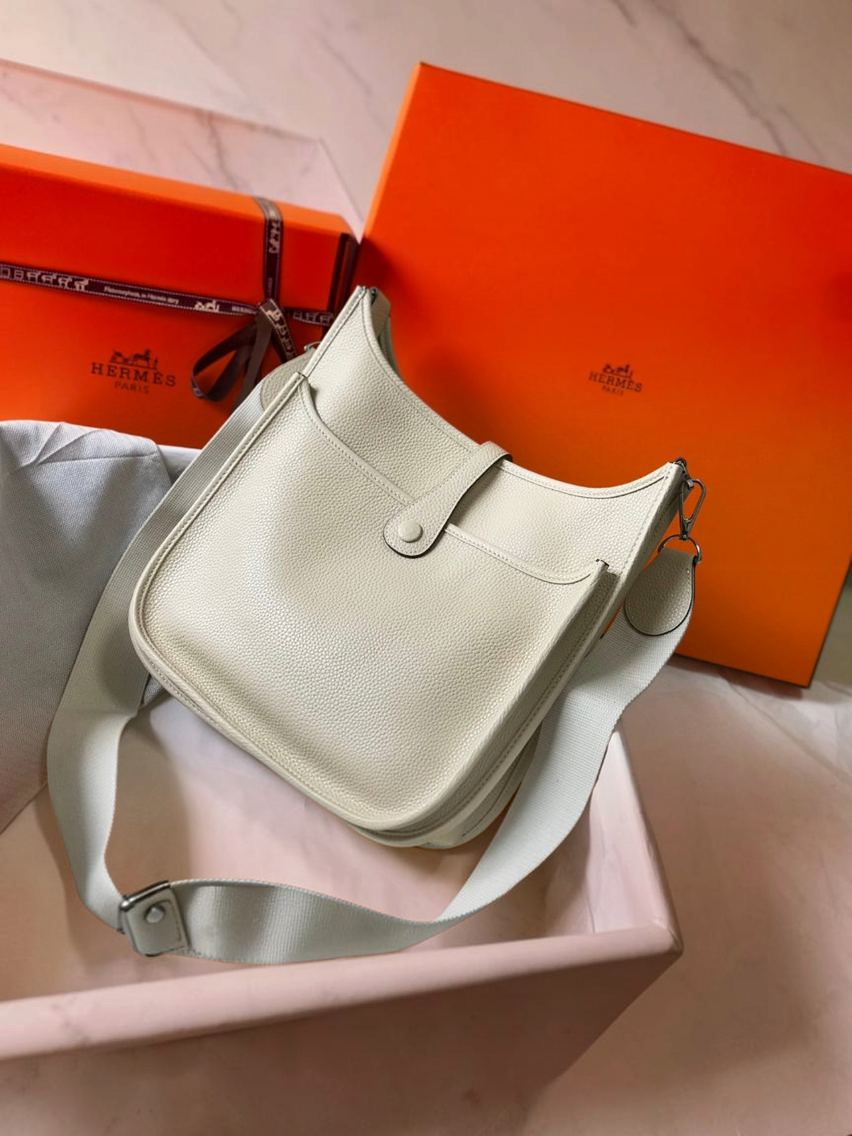 SWORD LUXURY beyaz deri Hermès Evelyne PM 28 çanta, ayarlanabilir kanvas askılı ve ikonik H logolu tasarım.