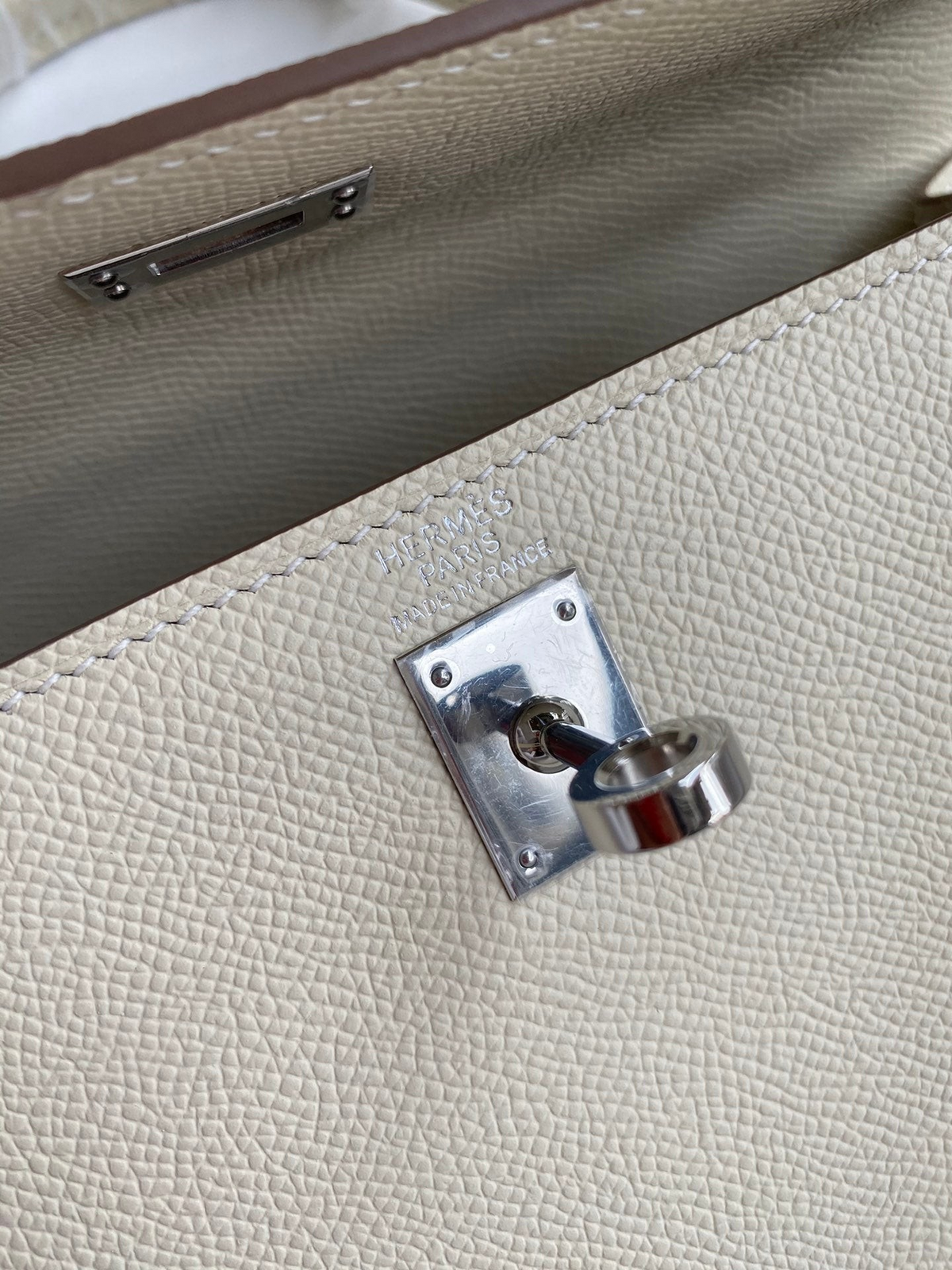 SWORD LUXURY Kelly 25 Epsom deri çanta, gümüş tonlu donanımı ve ikonik Hermès kilit detayı ile yakından görünüm.