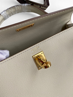 SWORD LUXURY Kelly 25 çanta, altın tonlu donanıma ve ikonik kilit mekanizmasına sahip bej Epsom deri detayları.