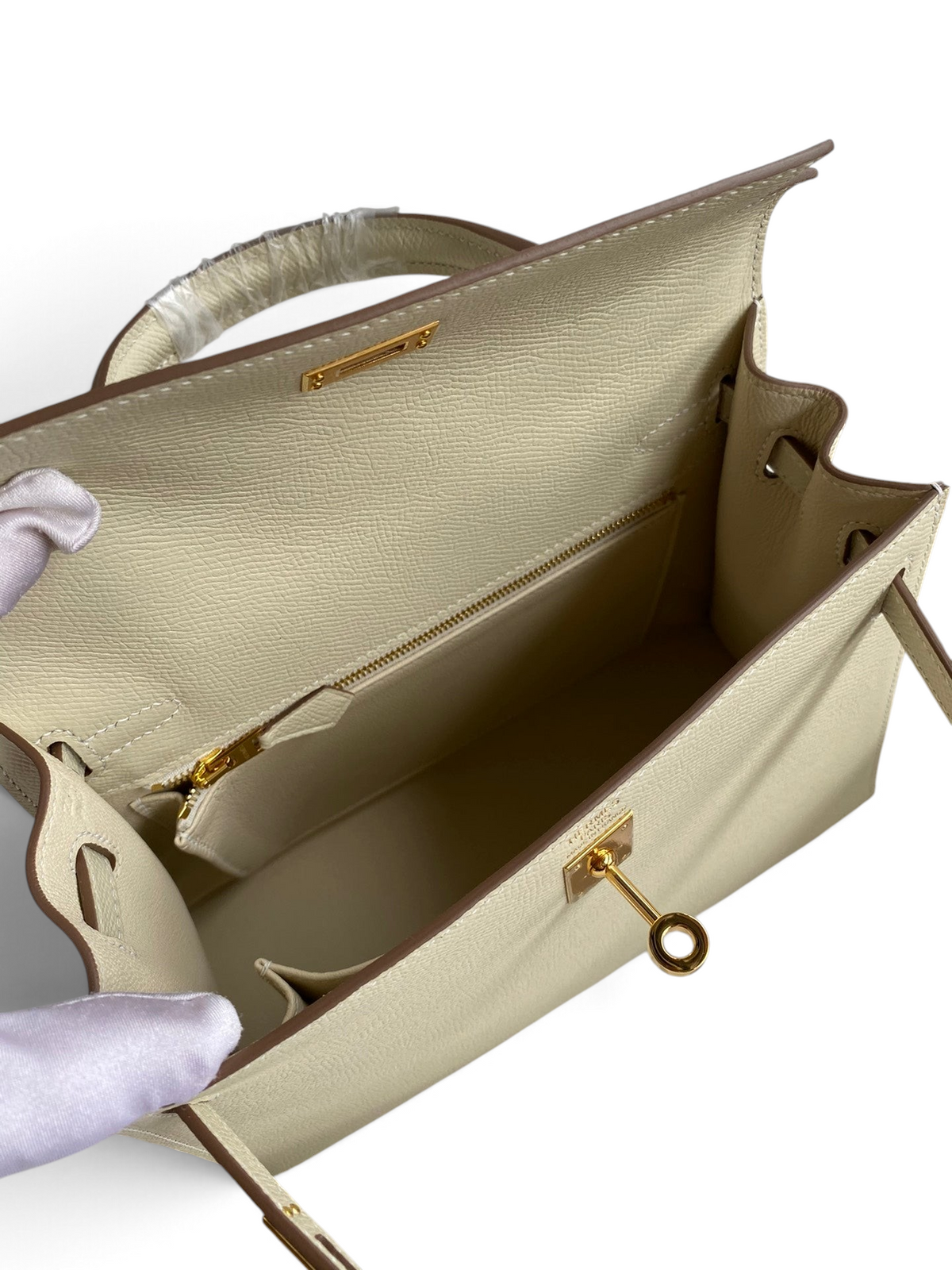 SWORD LUXURY marka, krem rengi Epsom deri Kelly 25 çanta, altın tonlu donanım ve iç fermuarlı bölme detaylı.