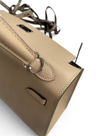 SWORD LUXURY bej renkli Epsom deri Kelly 25 çanta, gümüş tonlu donanım ve detaylı el dikişleri ile.
