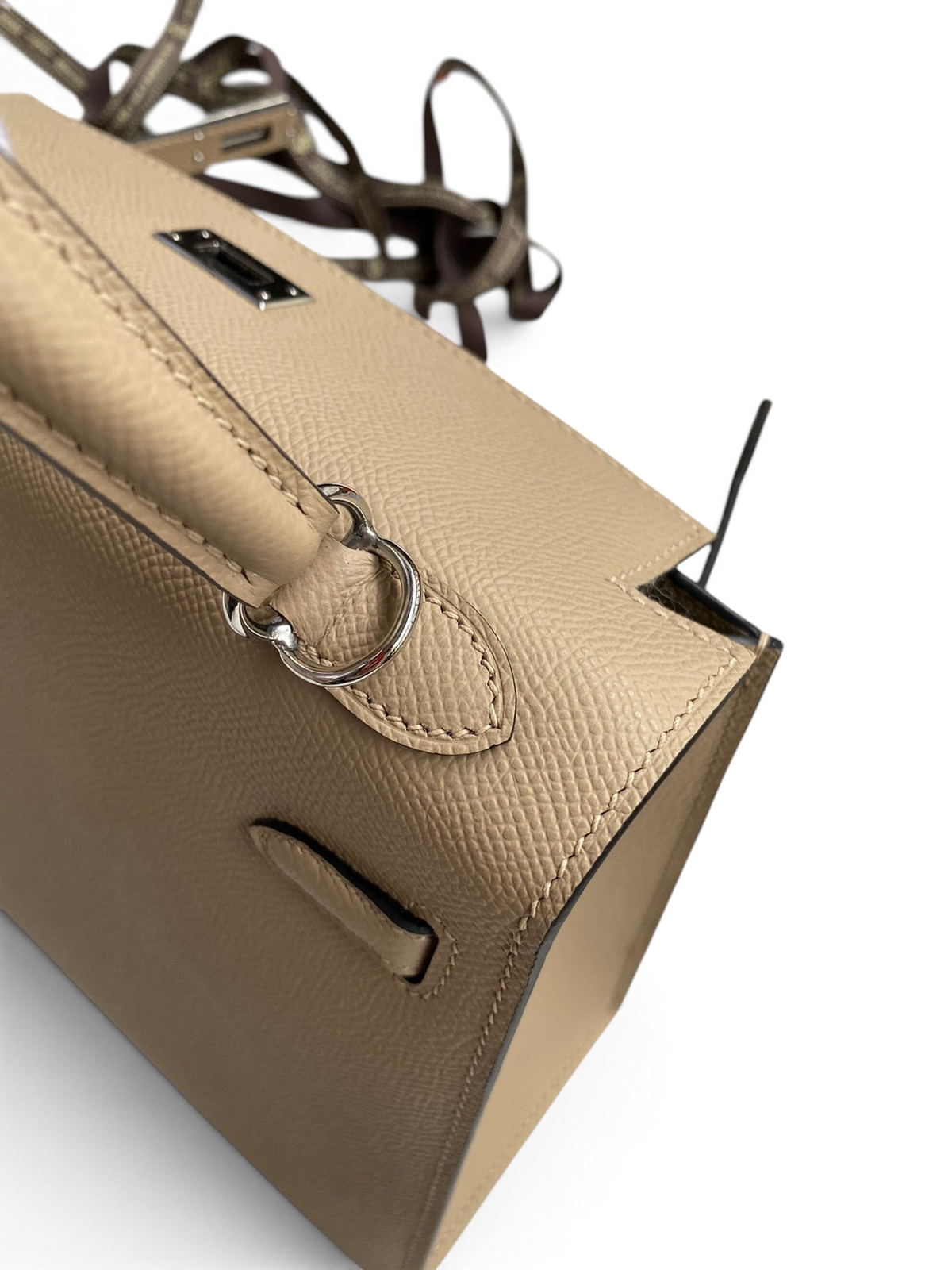 SWORD LUXURY bej renkli Epsom deri Kelly 25 çanta, gümüş tonlu donanım ve detaylı el dikişleri ile.