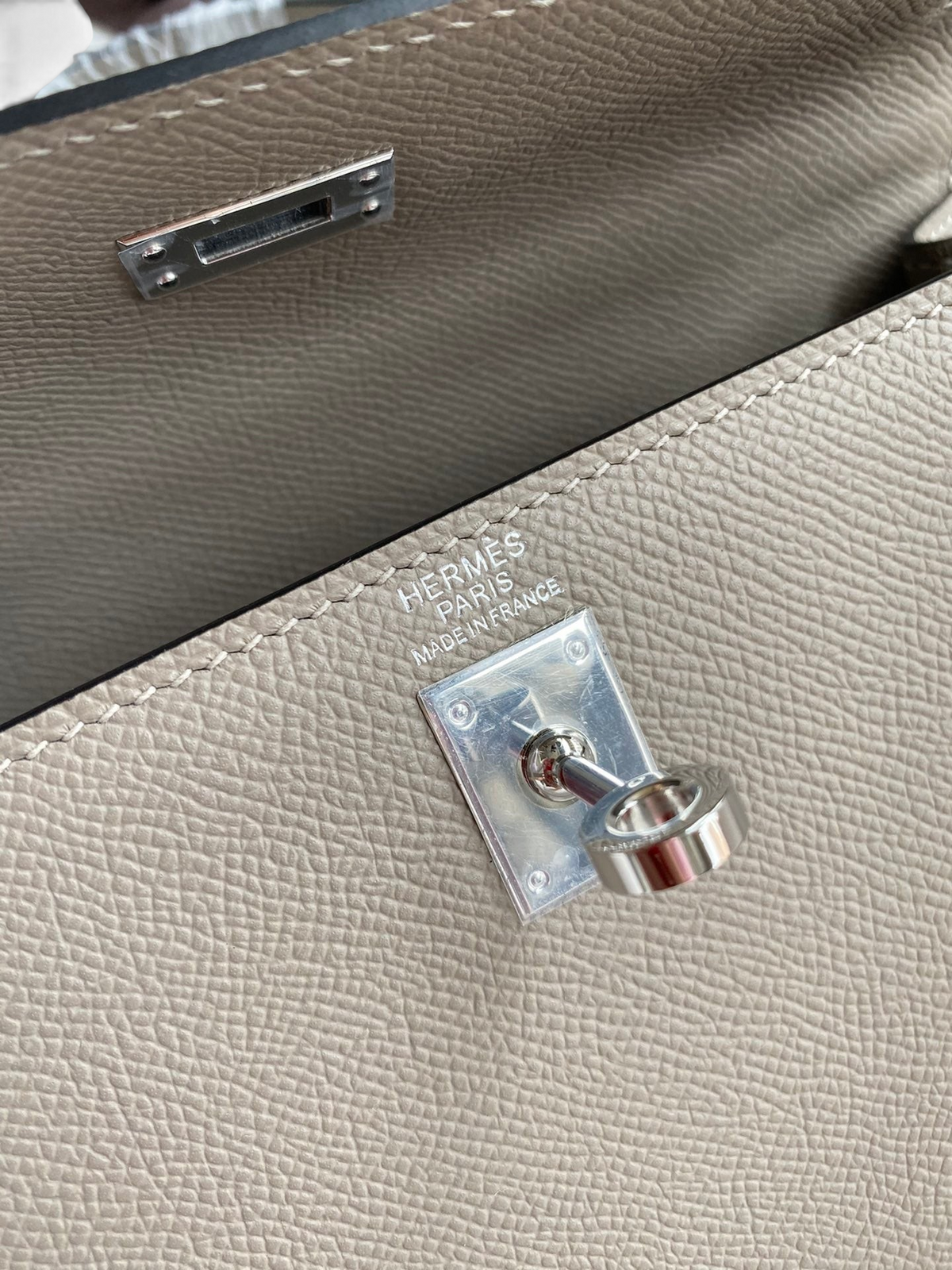 SWORD LUXURY marka bej rengi Epsom deri Kelly 25 çanta, gümüş tonlu palladium donanım ve ikonik kilit detayı.