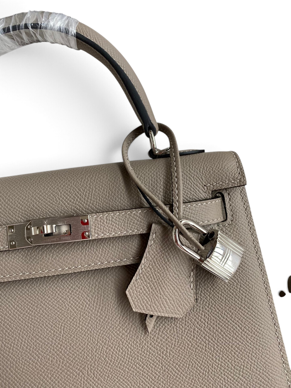 SWORD LUXURY marka gri Epsom deri Kelly 25 çanta, gümüş tonlu donanım, kilit ve anahtarlı clochette detayı ile.