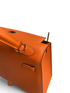SWORD LUXURY turuncu Epsom deri Hermès Kelly 25 çanta, altın tonlu donanım ve ikonik el işçiliği detaylarıyla.