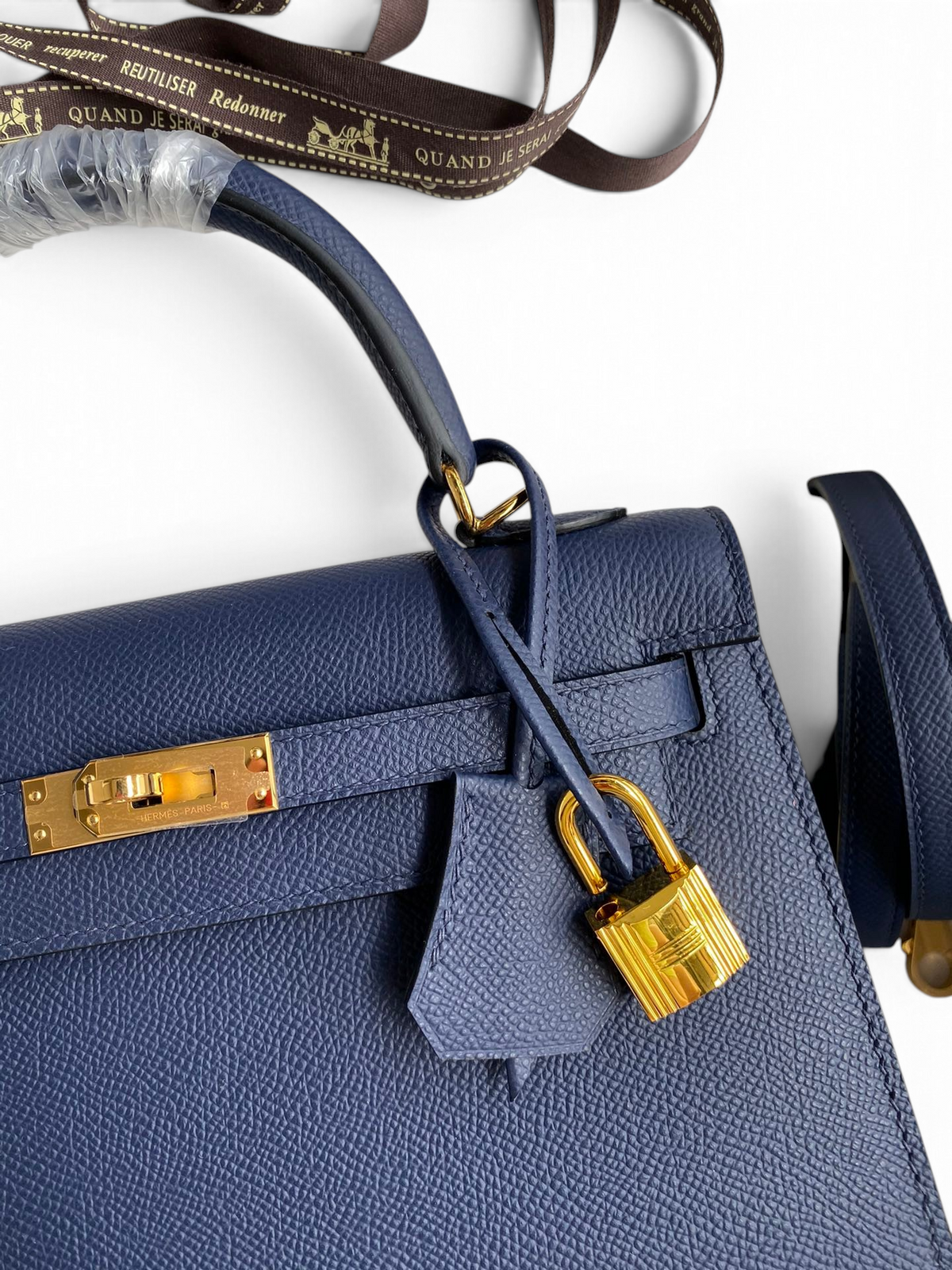 SWORD LUXURY lacivert Epsom deri Hermès Kelly 25 çanta, altın tonlu donanım, kilit ve anahtarlı clochette detaylı.