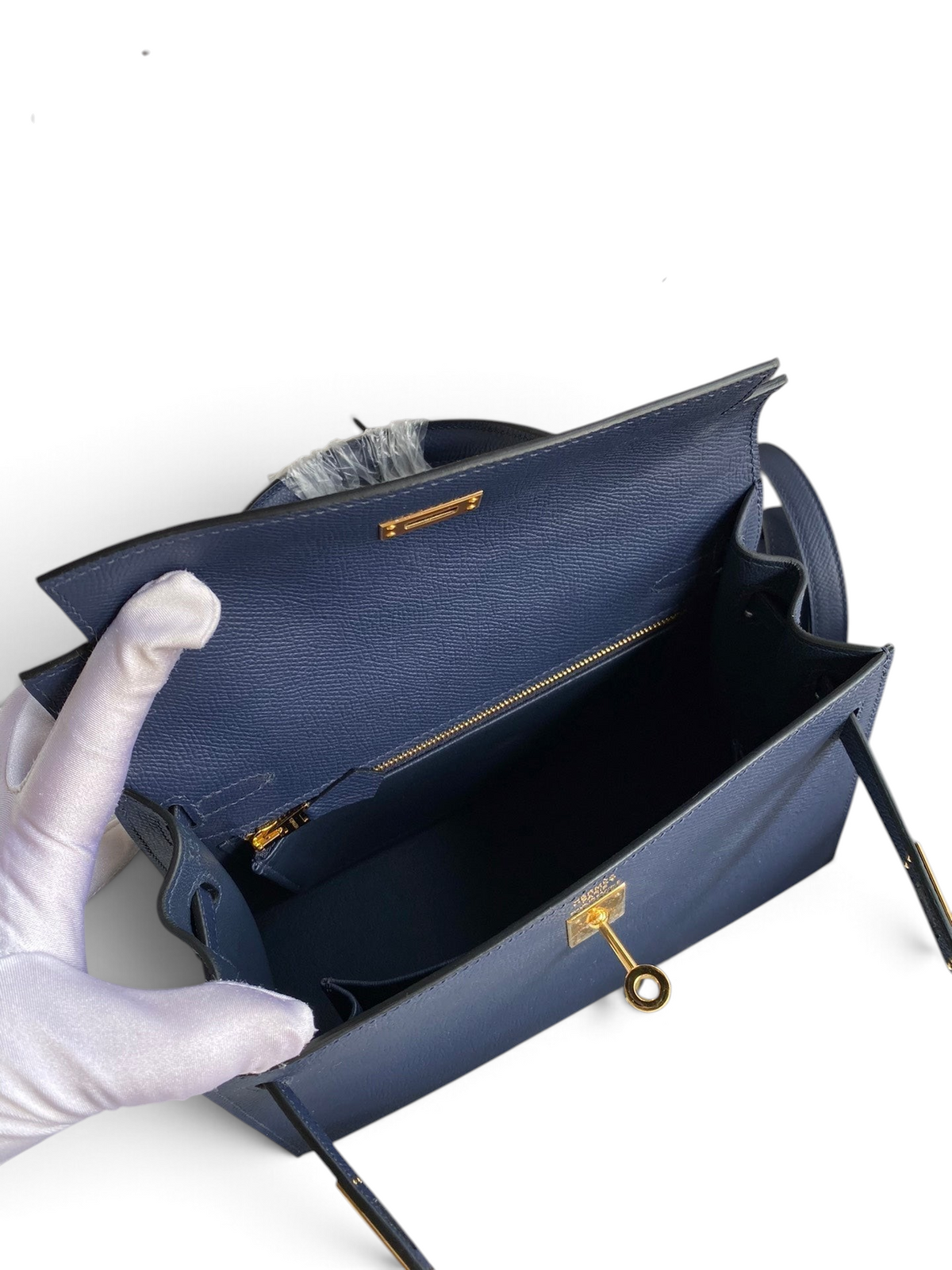 SWORD LUXURY lacivert Epsom deri Kelly 25 çanta, altın tonlu donanım ve iç bölmeleriyle kutusunda sergileniyor.
