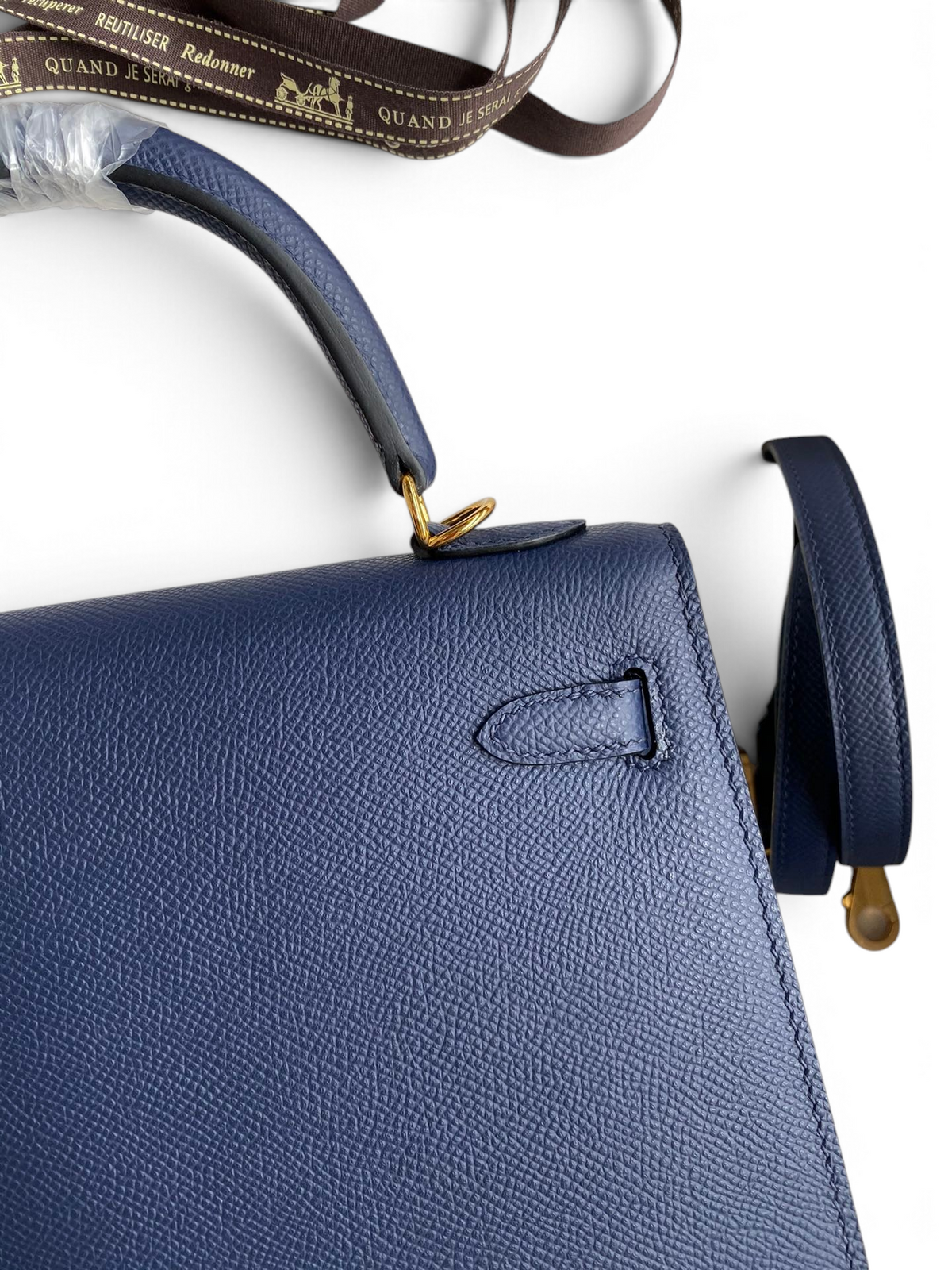 SWORD LUXURY lacivert Epsom deri Kelly 25 çanta, altın tonlu donanım ve çıkarılabilir omuz askısı ile detaylandırılmıştır.