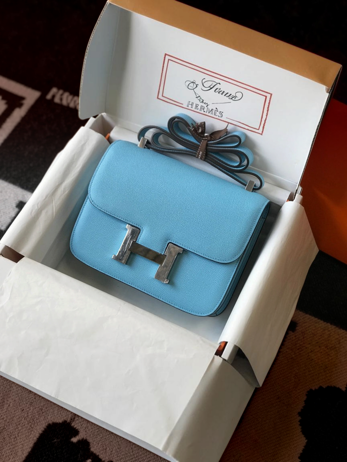 SWORD LUXURY marka, gümüş renkli H tokalı, açık mavi deri Hermès Constance 18 çanta, orijinal kutusunda.