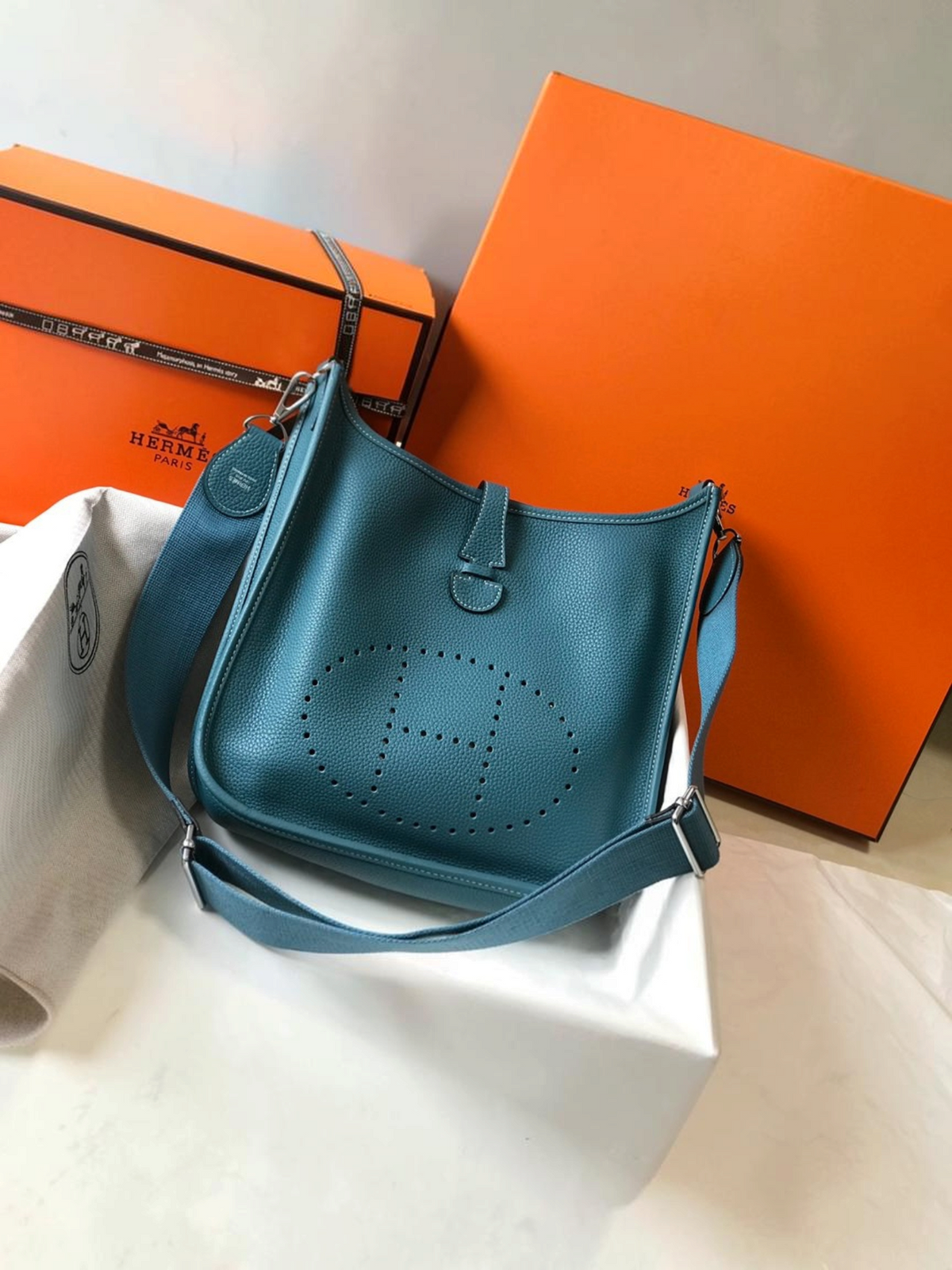 SWORD LUXURY marka, mavi renkli, delikli H logolu, deri Hermès Evelyne PM 28 çapraz çanta ve kutusu.