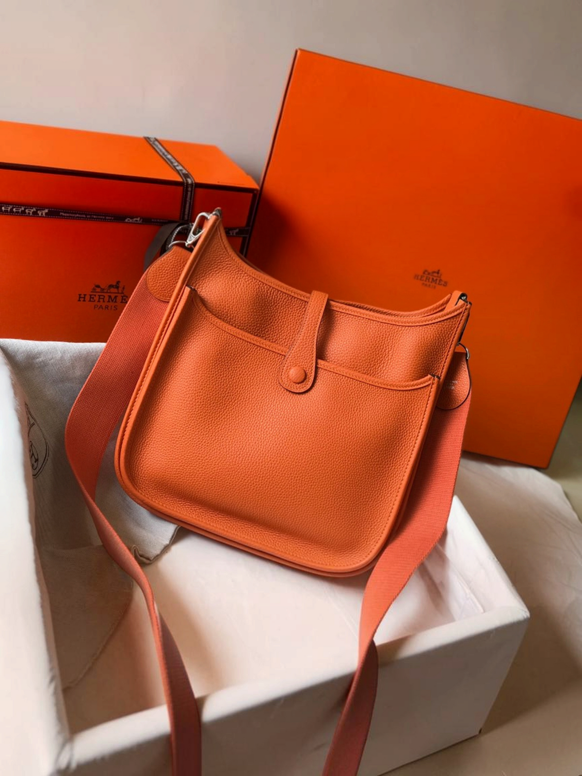 SWORD LUXURY turuncu deri Hermès Evelyne PM 28 çanta, ayarlanabilir kanvas askılı ve ikonik H logolu tasarım.