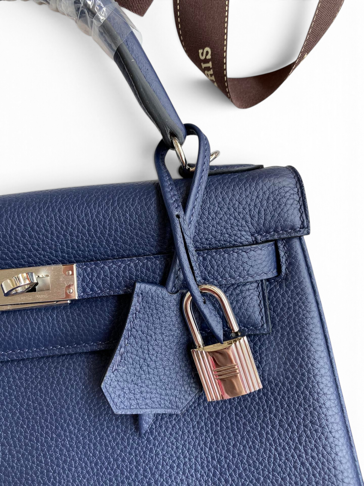 SWORD LUXURY lacivert Togo deri Kelly 25 çanta, gümüş donanımlı kilit ve ikonik el işçiliği detayları ile.