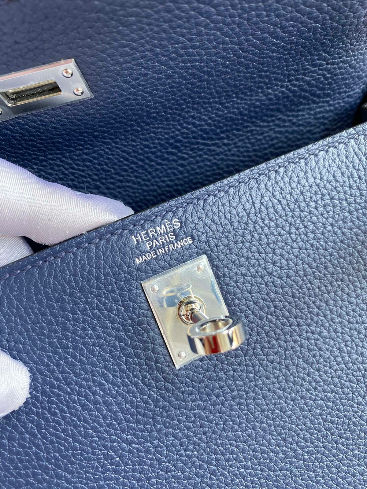 SWORD LUXURY Kelly 25 lacivert Togo deri çanta, gümüş donanımlı turn-lock kilit detayı ve iç damga logosu