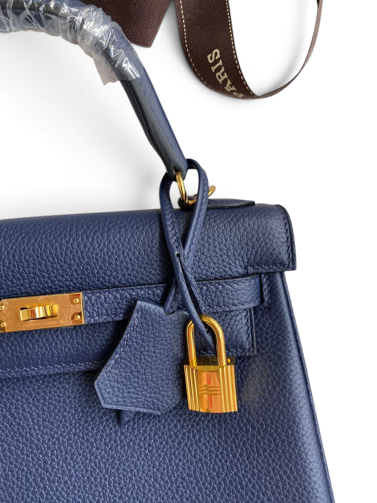 SWORD LUXURY lacivert Togo deri Kelly 25 çanta, altın rengi kilit ve ikonik turn-lock kapama detaylı.