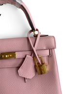 SWORD LUXURY Kelly 25 pembe Togo deri çanta, altın rengi kilit ve ikonik turn-lock kapama detaylı.