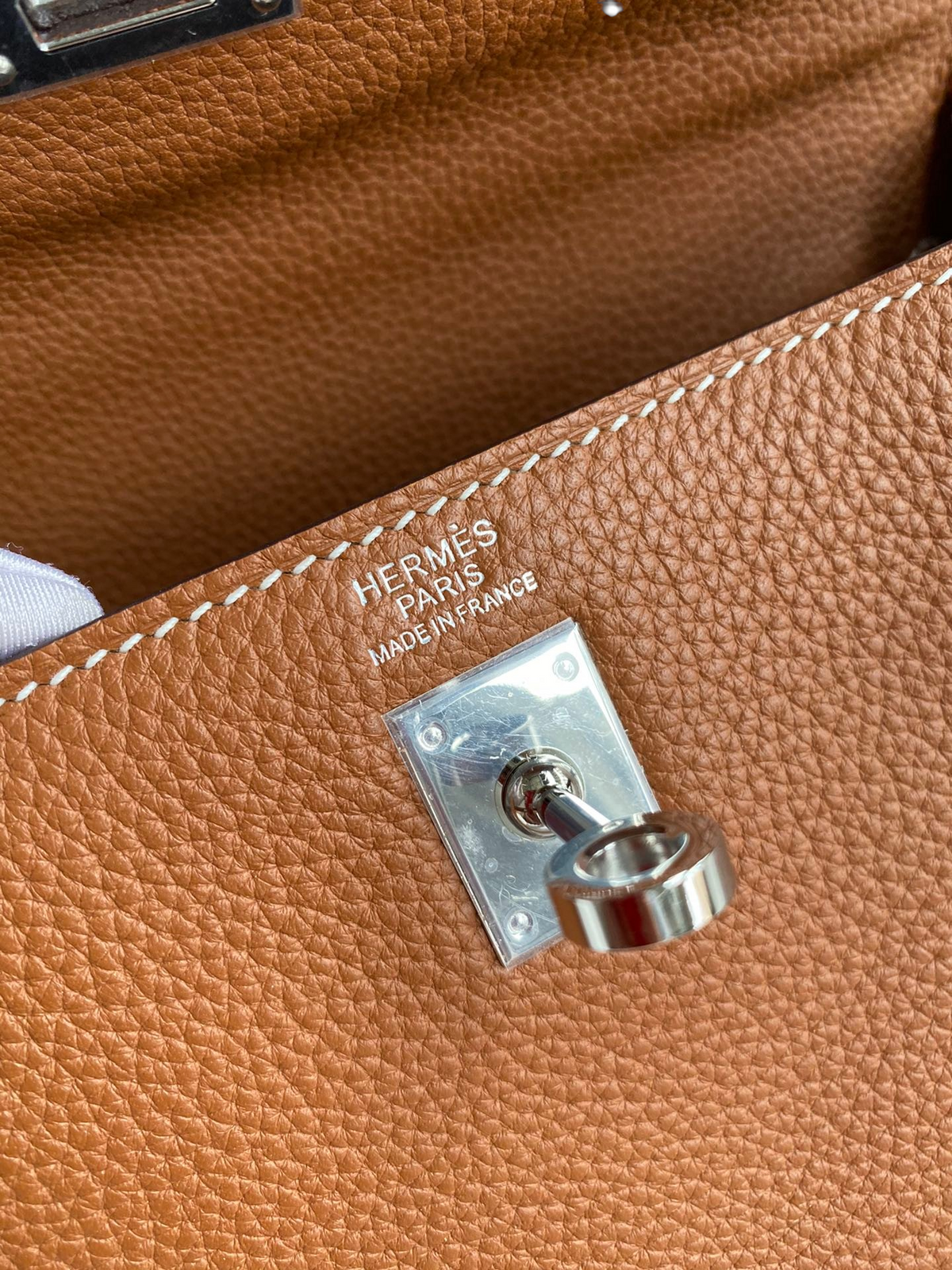 SWORD LUXURY Kelly 25 çanta, gümüş donanımlı taba rengi Togo deri detayları ve ikonik Hermès Paris damgası.