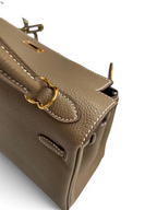 SWORD LUXURY Kelly 25 çanta, taupe renkli Togo deri dokusu, altın donanımı ve el işçiliği dikiş detaylarıyla.