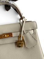 SWORD LUXURY Kelly 25 krem rengi Togo deri çanta, altın rengi kilit ve donanım detaylarıyla