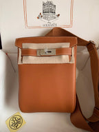 Brown leather bag with Hermès logo on a white background
