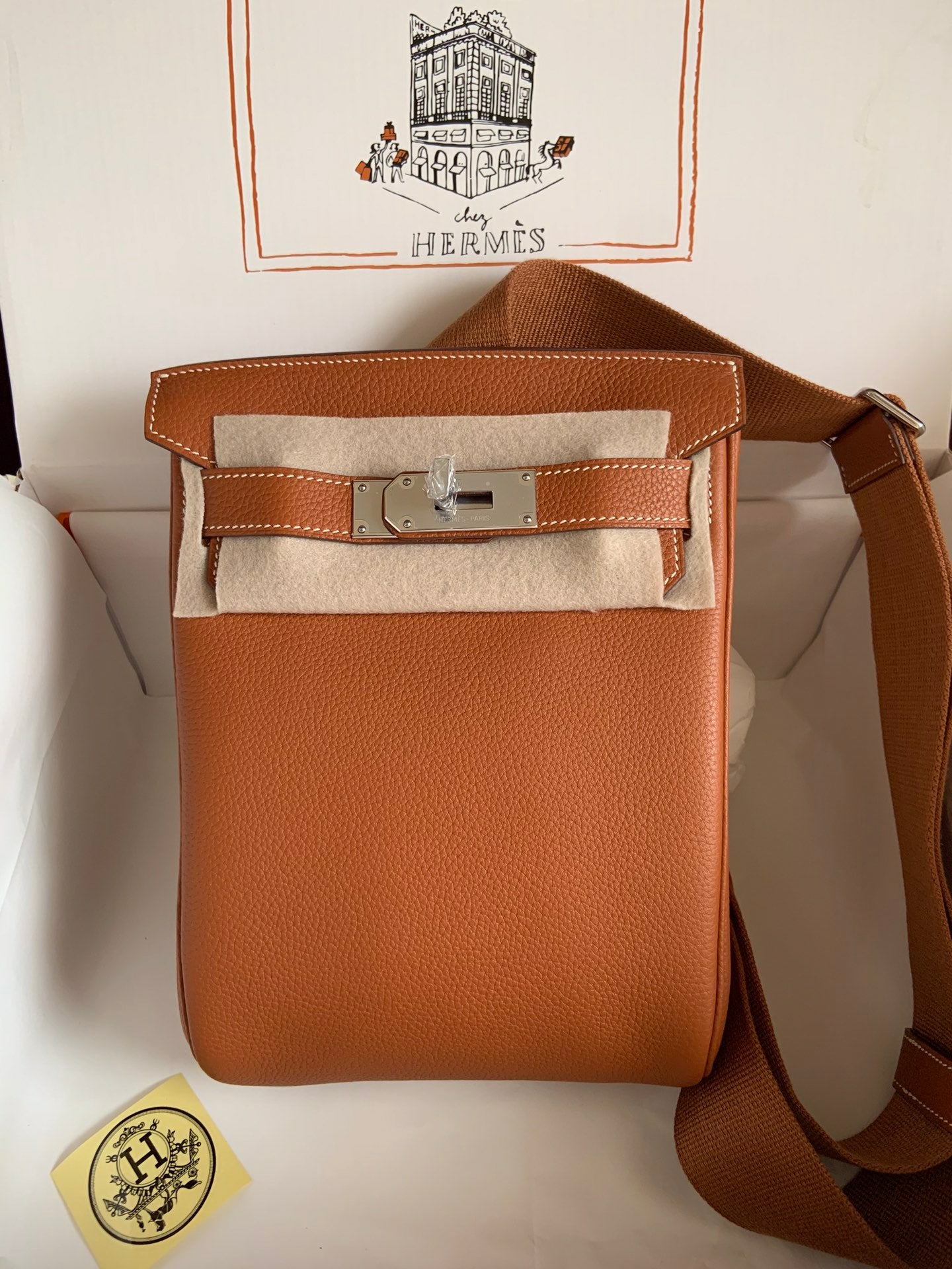 Brown leather bag with Hermès logo on a white background