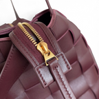 SWORD LUXURY Bottega Veneta Cassette Bowling çanta, bordo renkli, ikonik Intrecciato örgülü deri ve altın fermuar detayı.