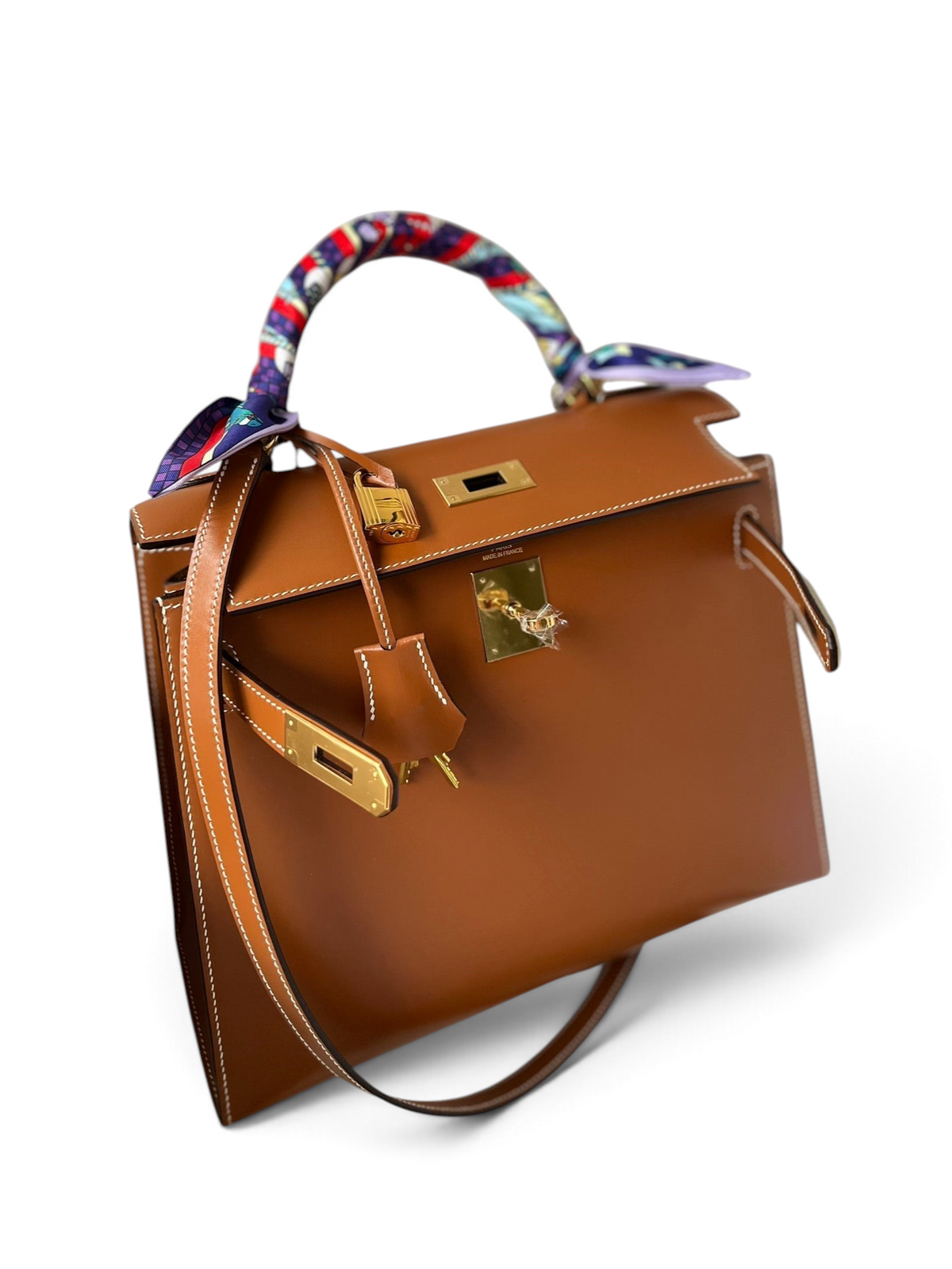 SWORD LUXURY marka, renkli twilly eşarp sarılı sapı ve altın donanımlı taba rengi deri Hermès Kelly 28cm çanta.