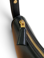 SWORD LUXURY siyah deri hilal çanta, altın tonlu fermuar detayı ve şık deri çekme ucu ile yakından görünüm.
