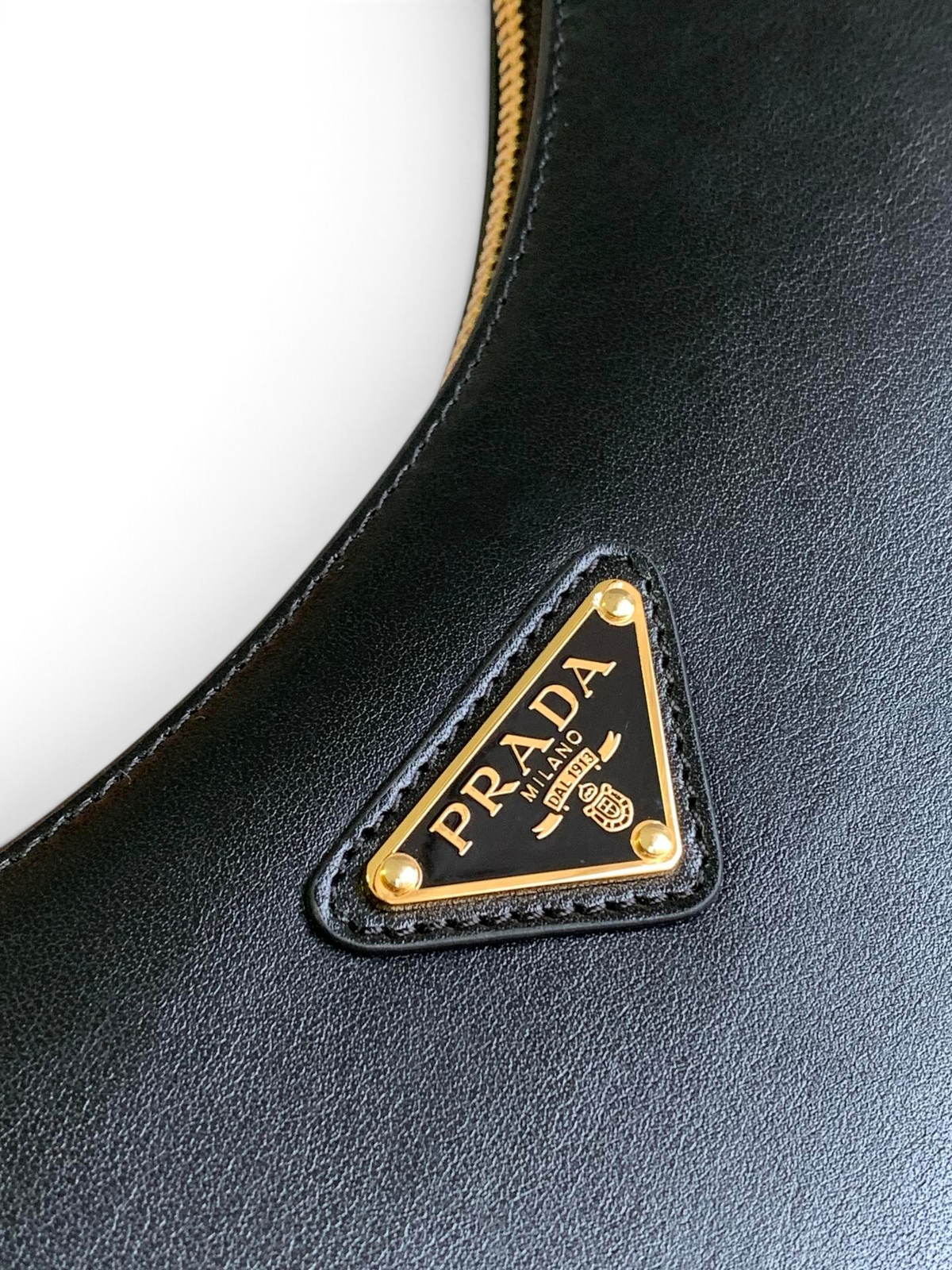 SWORD LUXURY siyah deri hilal çanta, altın tonlu metal logo detayı ve fermuar ile şık tasarım