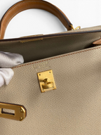 SWORD LUXURY Hermès Kelly 25 Epsom deri çanta, altın rengi metal kilit detayı ve iç kısımdaki marka damgası ile.