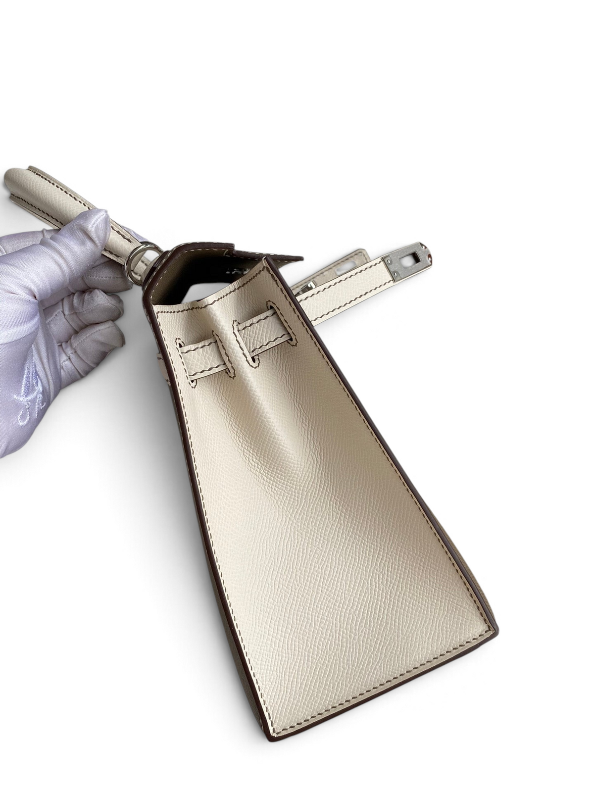 SWORD LUXURY marka, beyaz Epsom deriden üretilmiş, yan profilden görünen Hermès Kelly 25 çanta ve kutu içeriği.