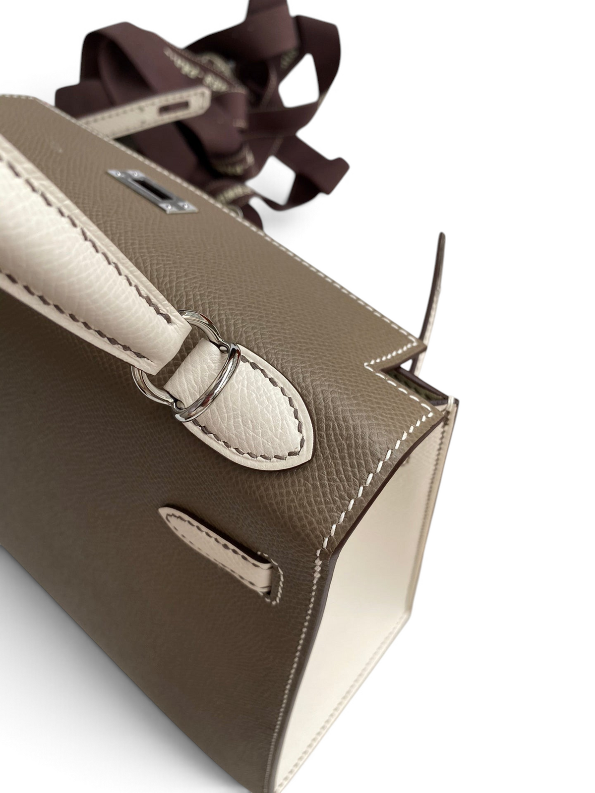 SWORD LUXURY Hermès Kelly 25 çanta, bej ve kahverengi Epsom deri detayları ve gümüş donanımı ile kutusunda.