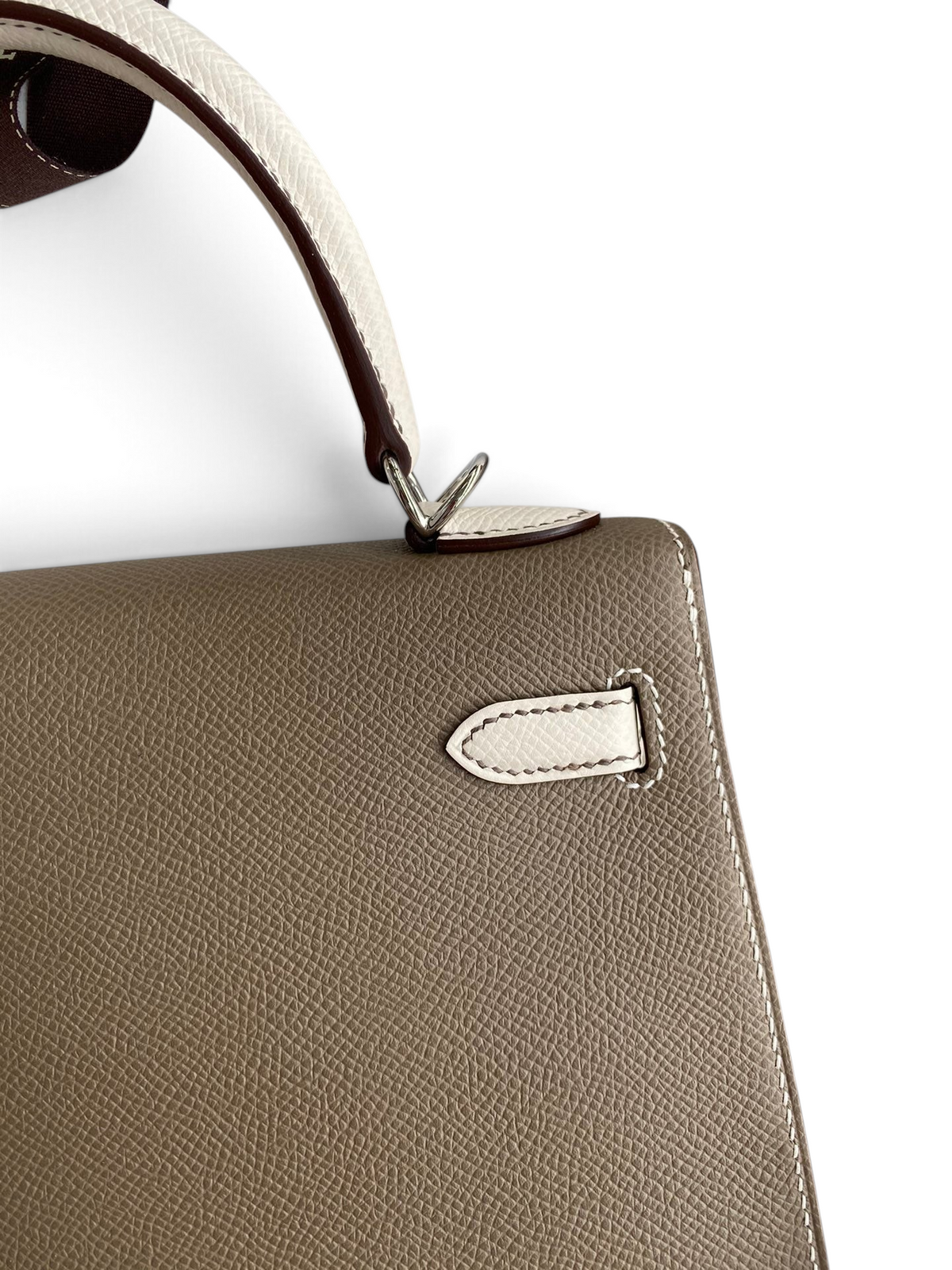 SWORD LUXURY marka, bej ve beyaz renkli, Epsom deri Hermès Kelly 25 çanta, detaylı dikişleri ve zarif tasarımıyla.