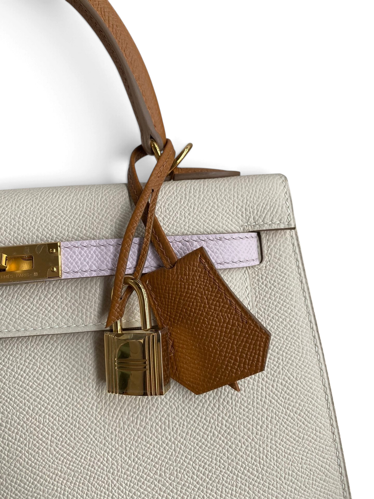 SWORD LUXURY Hermès Kelly 25 çanta, beyaz Epsom deri, taba rengi detaylar ve altın rengi kilitli turn-lock mekanizması.