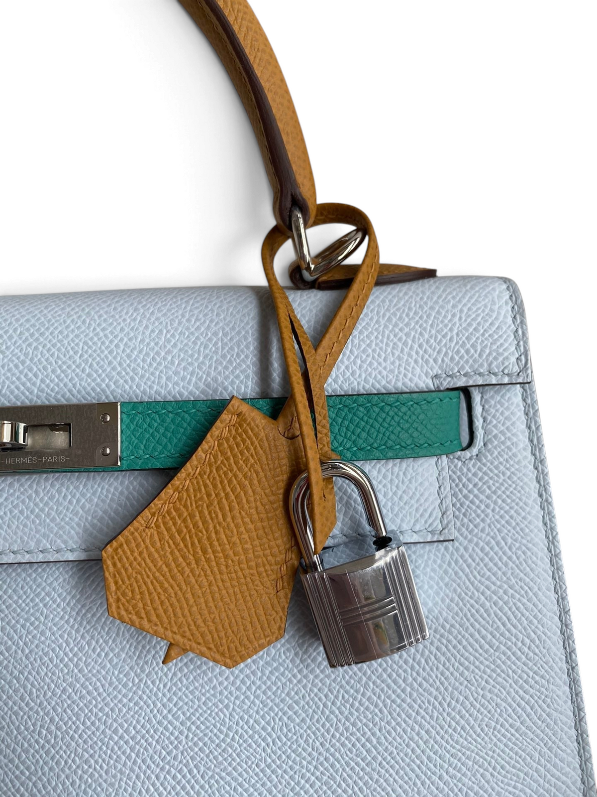 SWORD LUXURY marka, açık mavi Epsom deri Hermès Kelly 25 çanta, yeşil detaylı ve gümüş kilitli tasarım.