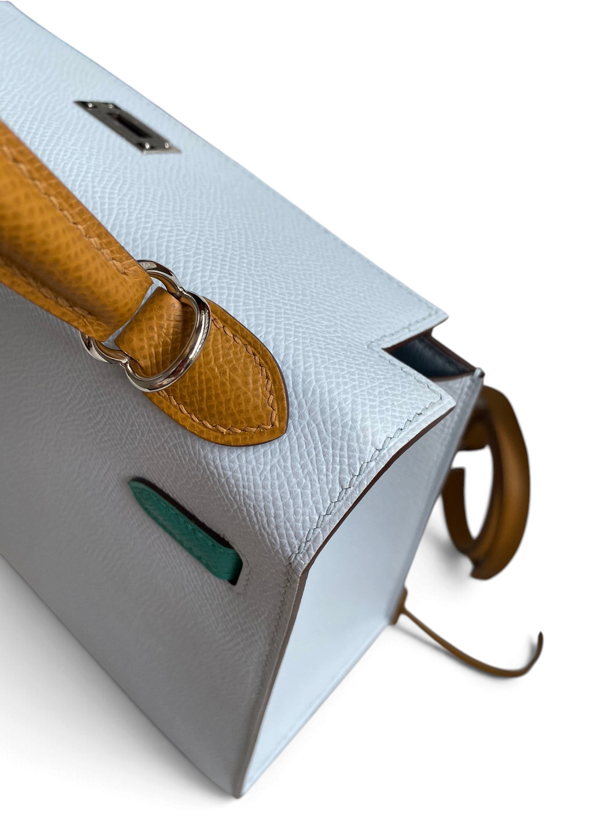 SWORD LUXURY Hermès Kelly 25 Epsom deri çanta, beyaz gövde ve kontrast sarı deri sap detaylı, yandan görünüm.