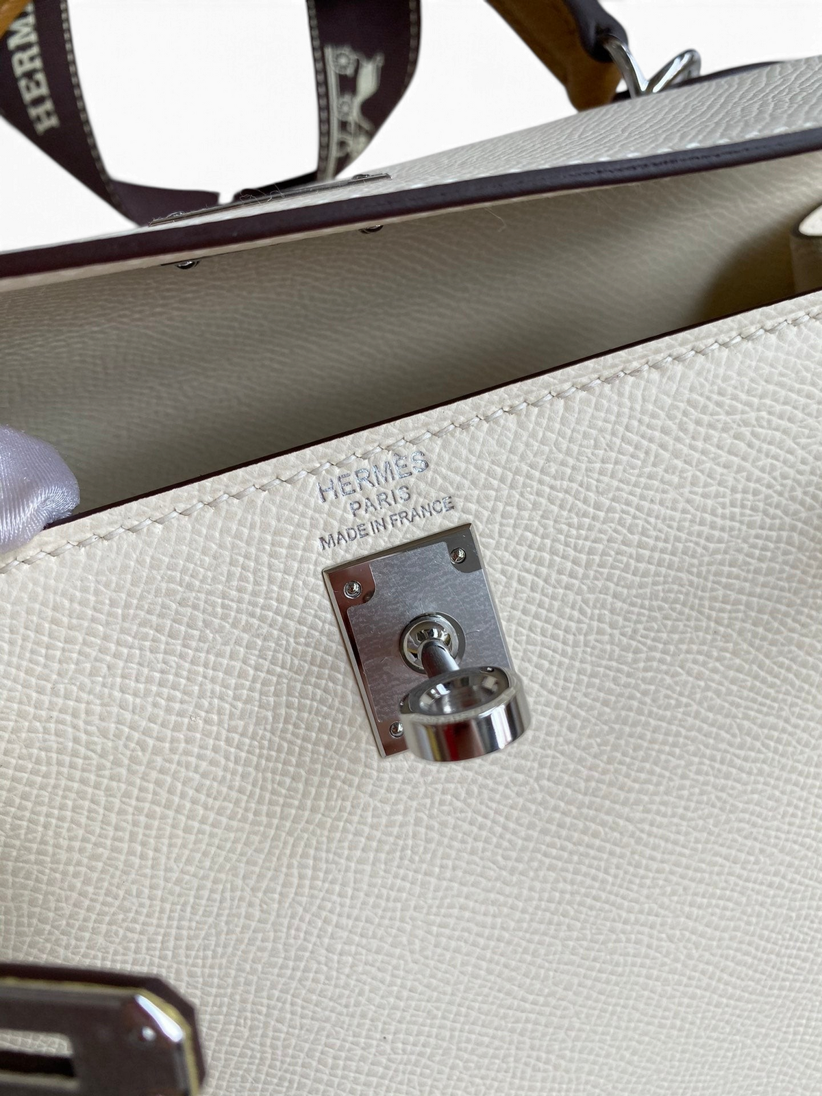 SWORD LUXURY Hermès Kelly 25 çanta, beyaz Epsom deri detayları ve gümüş renkli metal kilit mekanizması ile.