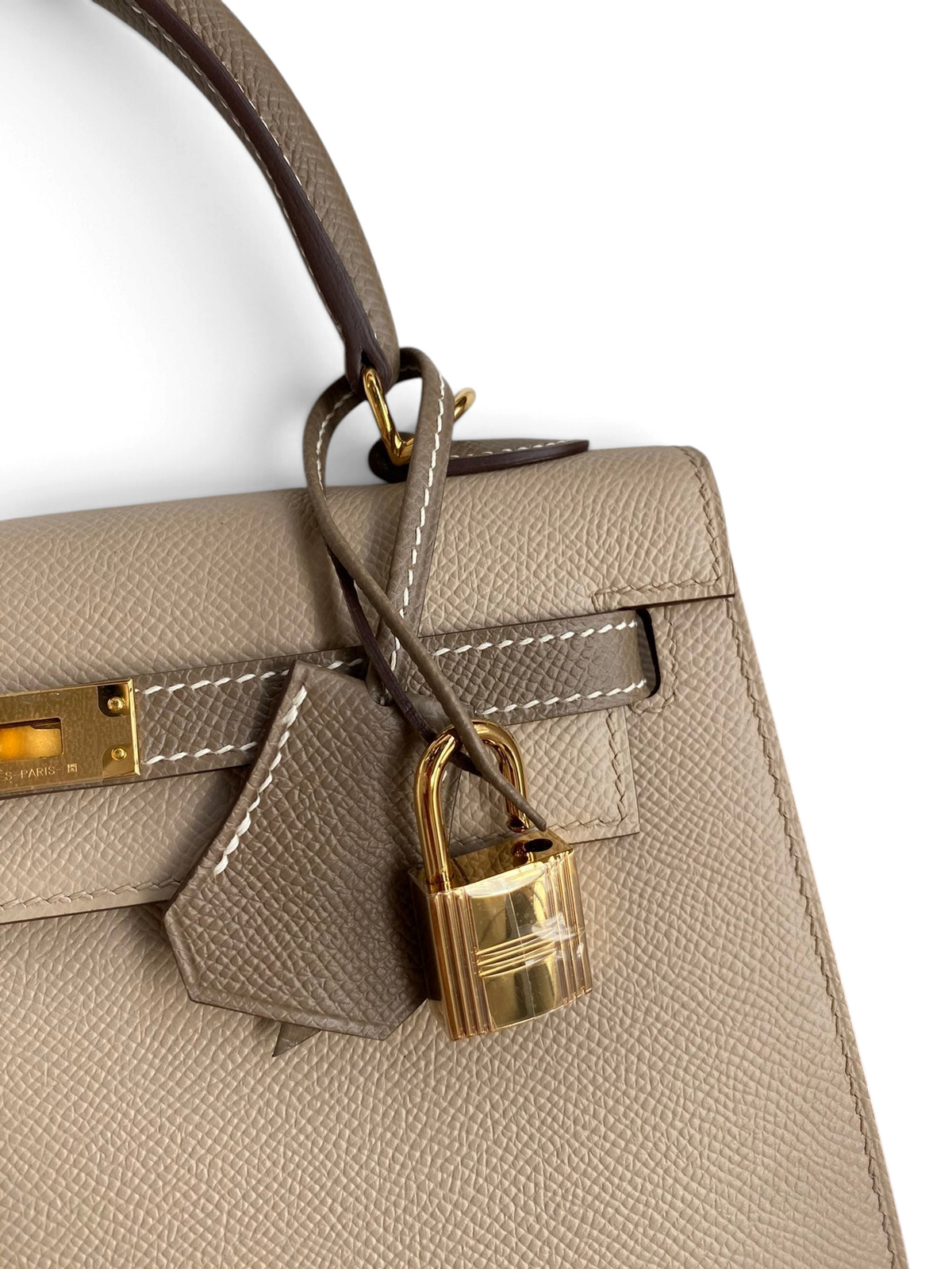SWORD LUXURY marka, altın donanımlı ve asma kilit detaylı, bej renkli Epsom deri Hermès Kelly 25 çanta.