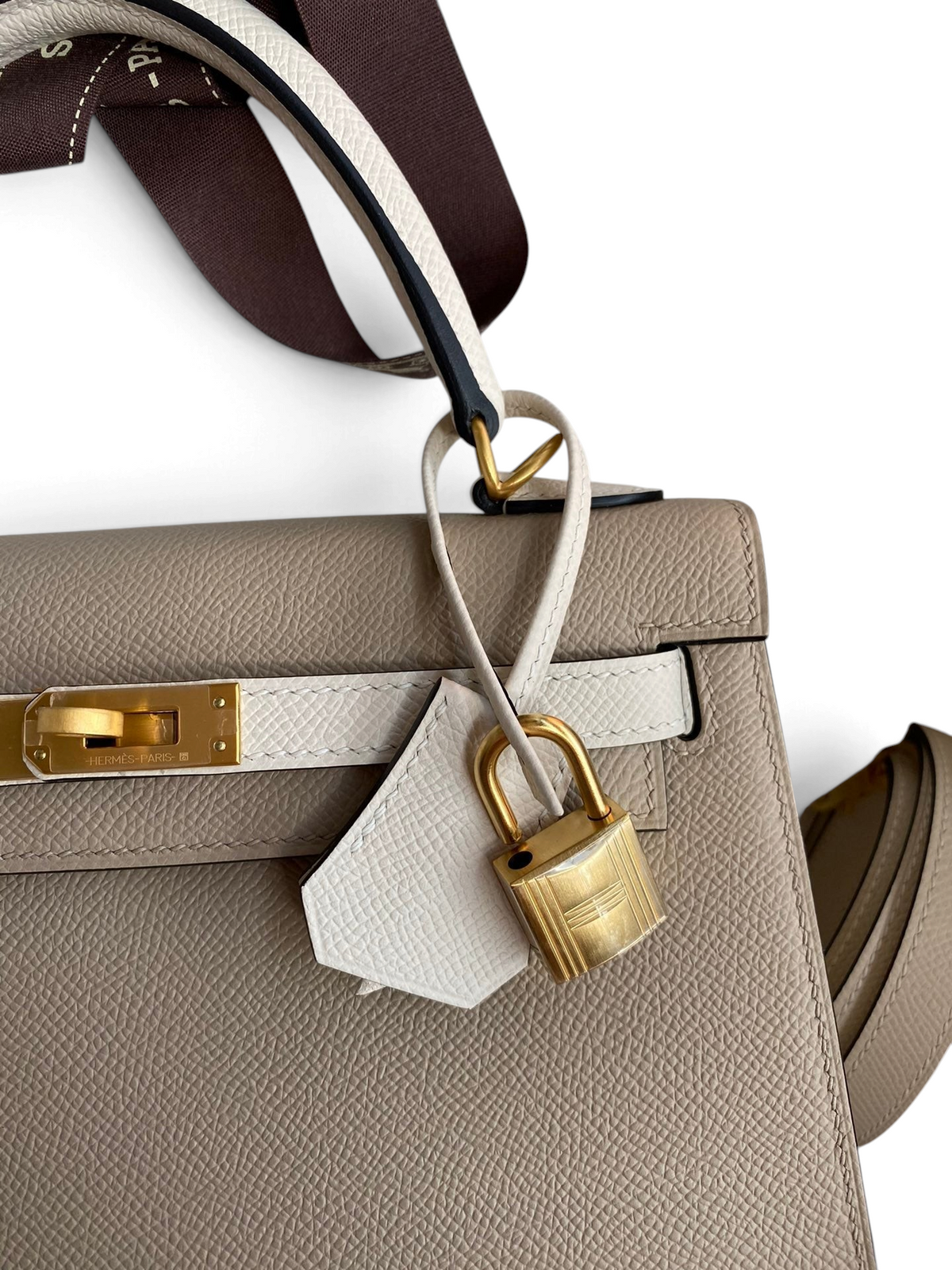 SWORD LUXURY marka, altın donanımlı ve asma kilit detaylı, bej renkli Epsom deri Hermès Kelly 25 çanta.
