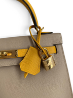 SWORD LUXURY marka, sarı detaylı bej renkli Epsom deri Hermès Kelly 25 çanta, altın rengi kilit ve anahtarlık ile.