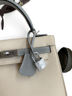SWORD LUXURY Gris Tourterelle Epsom deri Hermès Kelly 25 çanta, gümüş tonlu palladium donanım ve asma kilit detaylı.