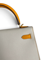 SWORD LUXURY marka, gri Epsom deri ve sarı detaylı, ikonik Hermès Kelly 25 çanta detayı.