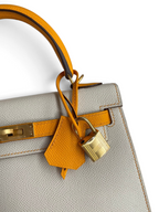 SWORD LUXURY Hermès Kelly 25 çanta, gri Epsom deri gövde ve turuncu deri detaylar ile altın tonlu kilit mekanizması.