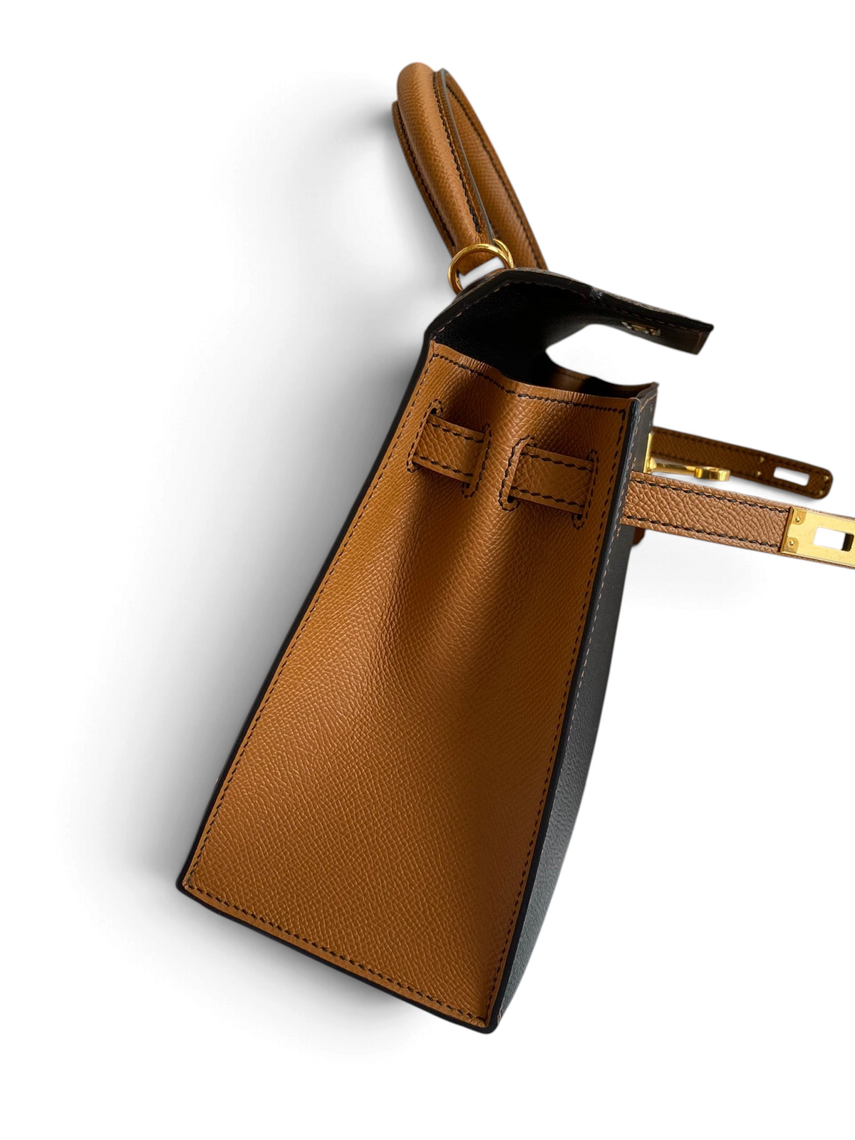 SWORD LUXURY Hermès Kelly 25 çanta, siyah ve taba rengi Epsom deri detayları ve altın donanımı ile yandan görünüm.