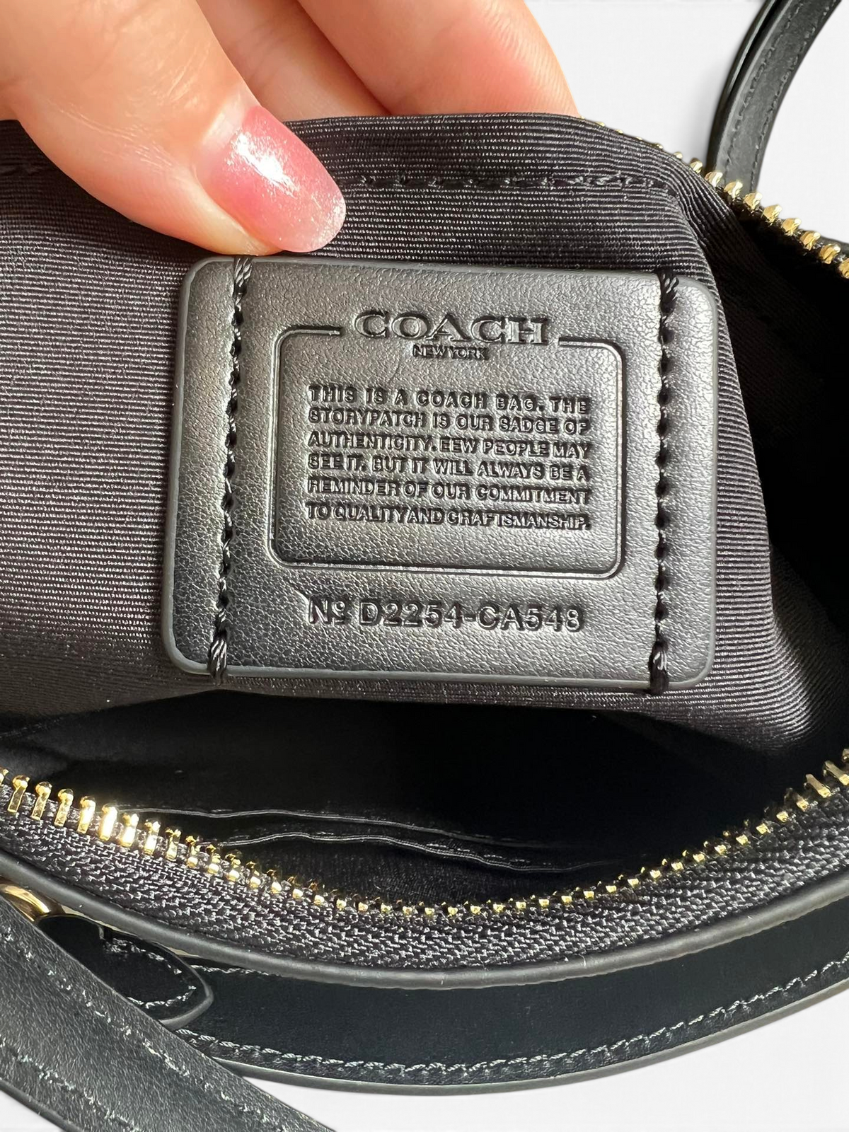 SWORD LUXURY Coach Teri omuz çantası iç kısmındaki deri otantiklik etiketi ve altın rengi fermuar detayı.