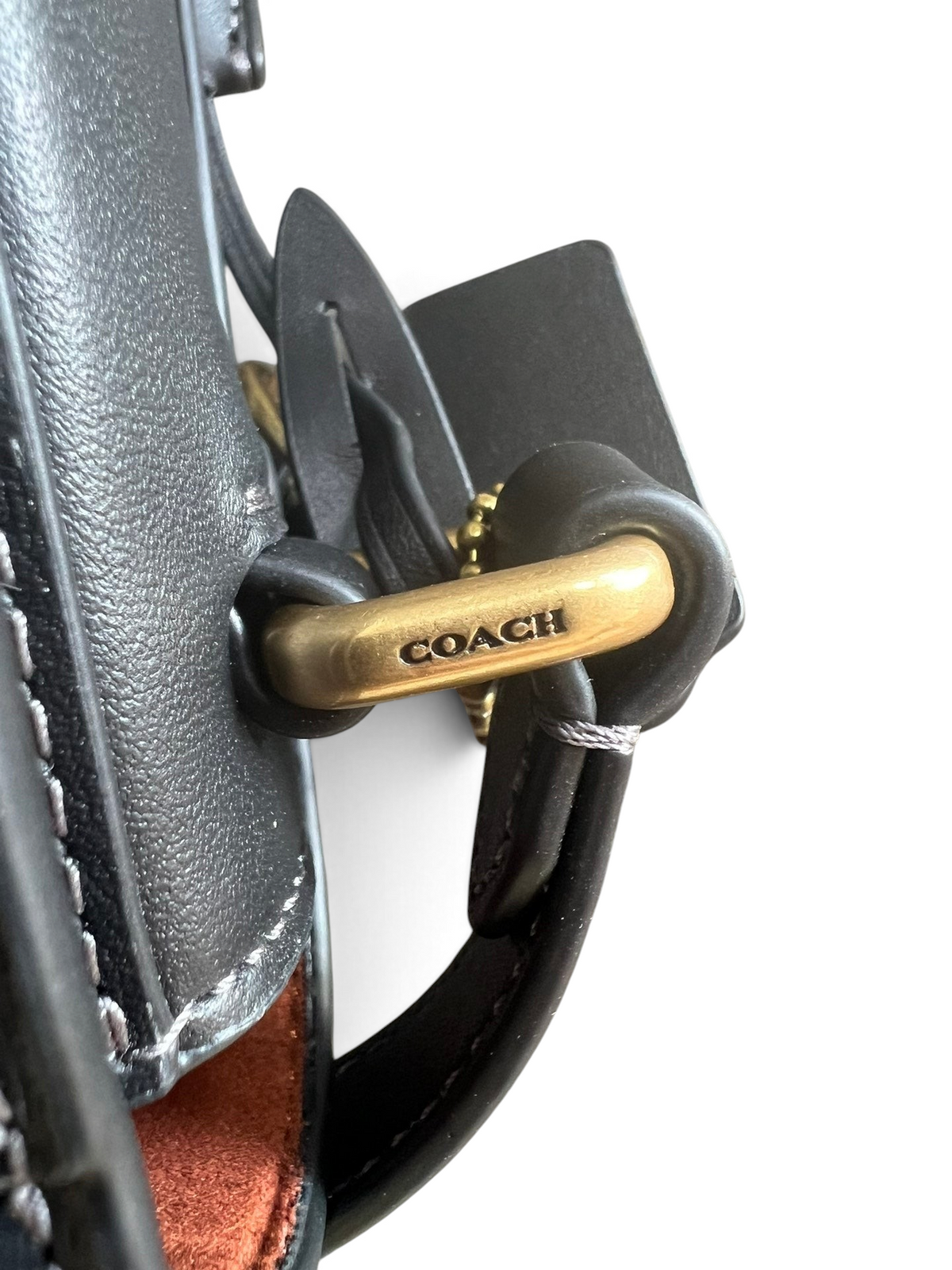 SWORD LUXURY Coach Studio 19 siyah deri omuz çantasının altın renkli metal detayları ve marka logosu yakın çekimi