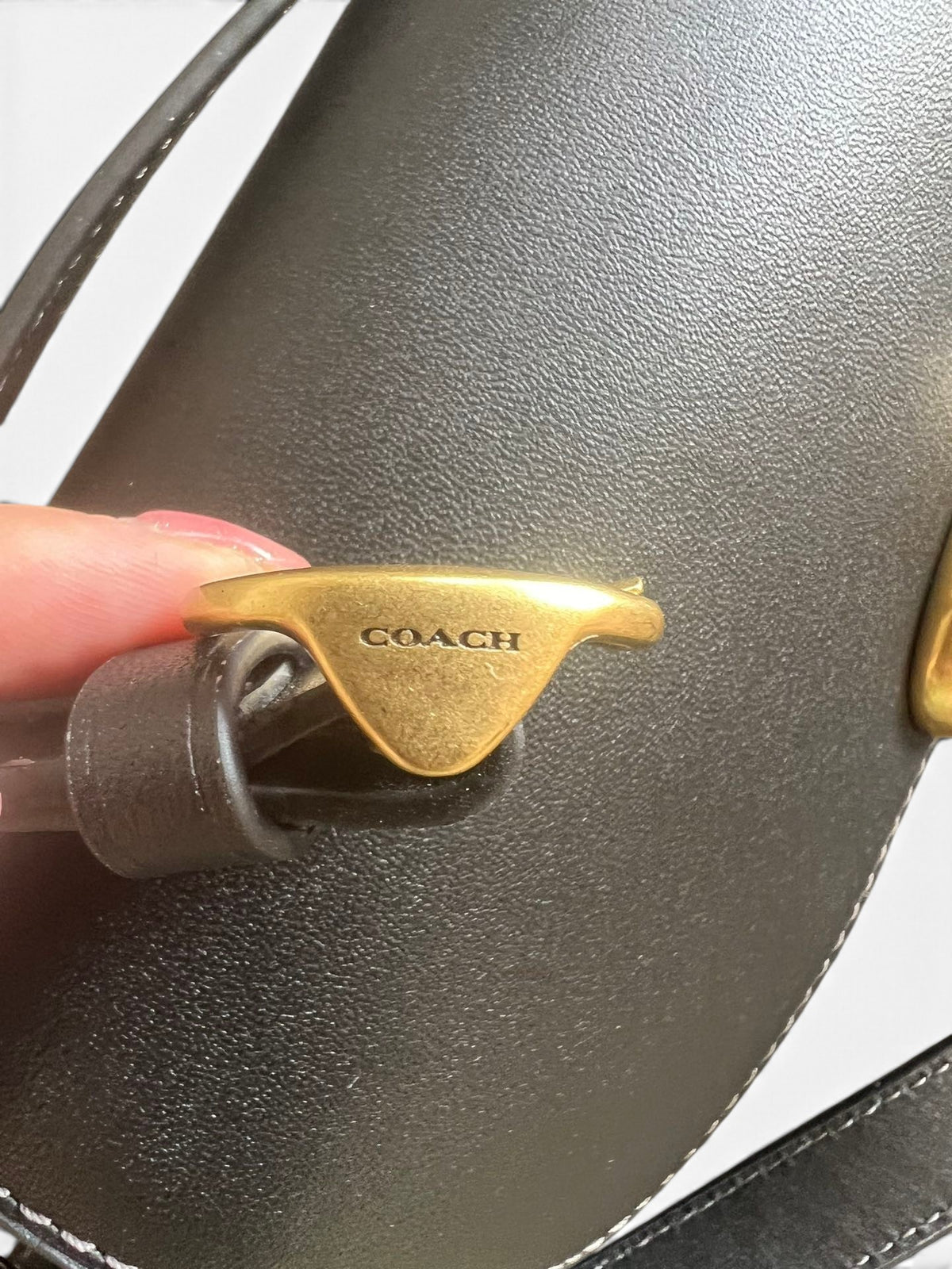 SWORD LUXURY Coach Studio 19 siyah deri omuz çantasının altın tonlu metal C kilit detayı ve pürüzsüz deri dokusu.